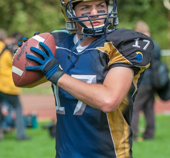a football player holding a football on a field